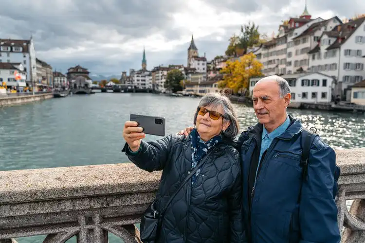 Homem e mulher que contrataram o melhor seguro viagem para idosos aproveitando a Suíça. 