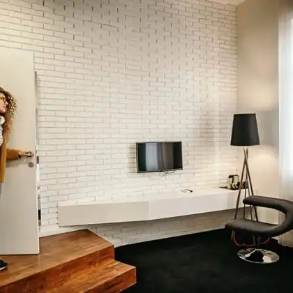 Mulher entrando na sala de apartamento alugado pela Uniplaces