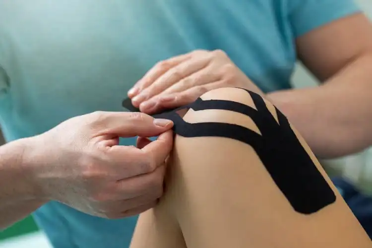Profissional de fisioterapia aplica bandagem em paciente