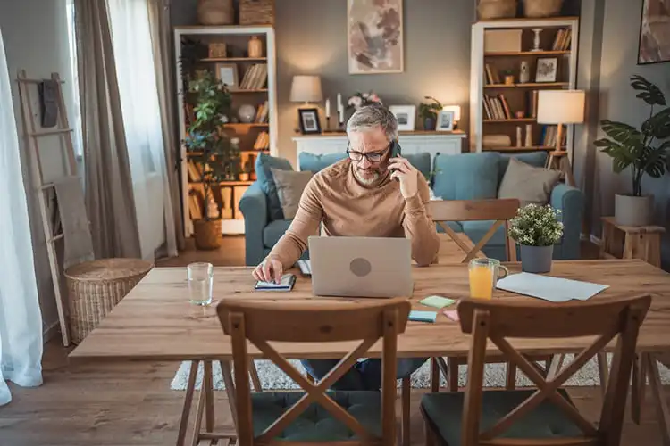 Homem com celular usando computador