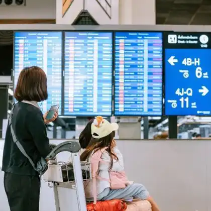 Indenização por overbooking: mulher e criança olhando painel de aeroporto