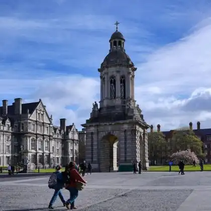 Turistas passeando em frente à Trinity College em Dublin