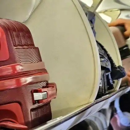 Mala de bordo no compartimento da cabine do avião.
