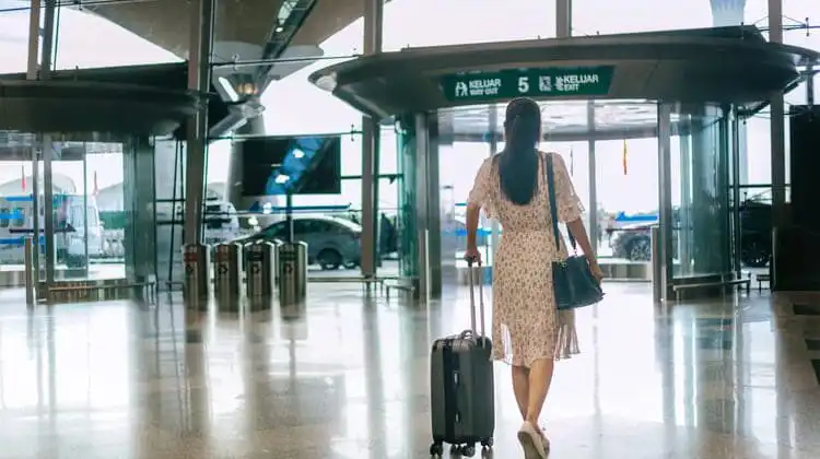 Mulher com mala para bagagem de mão no aeroporto.