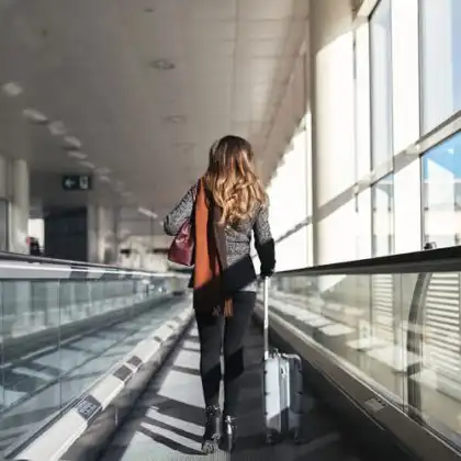 Mulher andando com mala em aeroporto