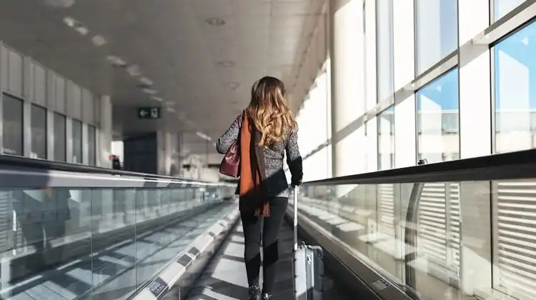Mulher andando com mala em aeroporto