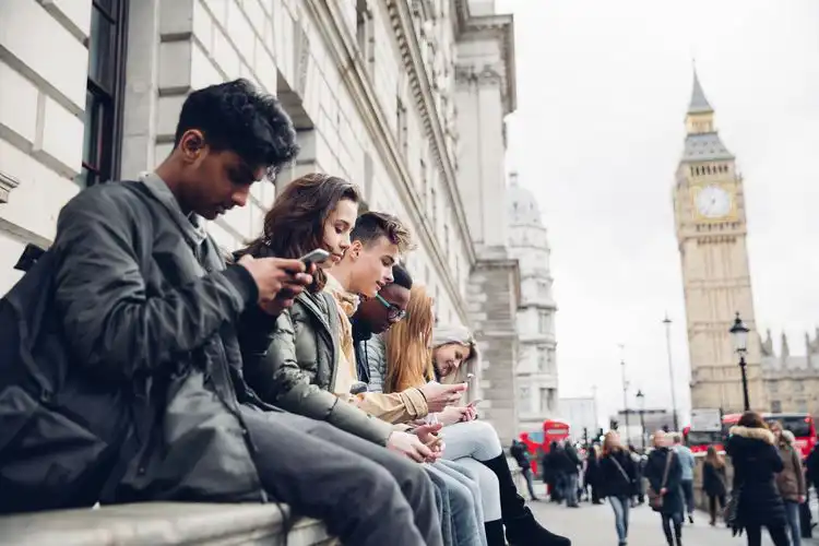 Grupo de jovens acessando a internet no smartphone com chip de internet em Londres. 