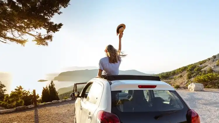 Mulher curtindo viagem de carro que alugou no melhor site para alugar carro