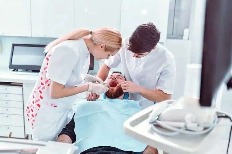 Dentista e colega ao examinar a condição do paciente