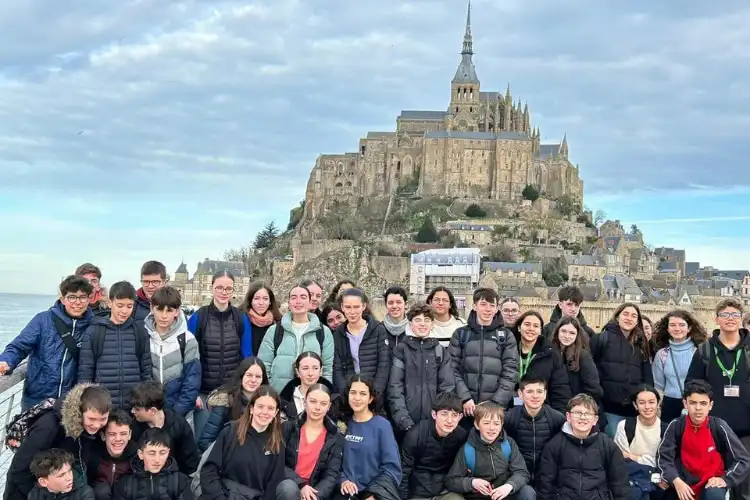 Grupo de alunos reunidos em frente ao Monte Saint-Michel.