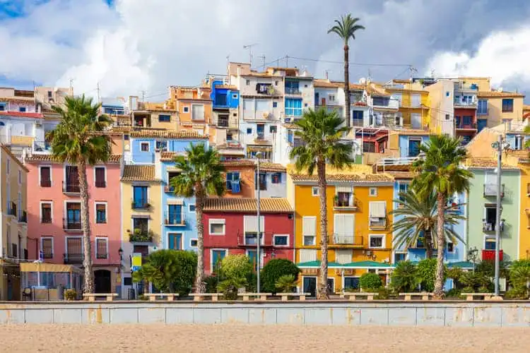 Orla de Alicante com casas coloridas e palmeiras.