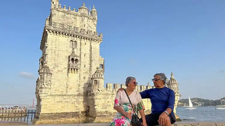 Casal aposentado em frente à Torre de Belém, Portugal.