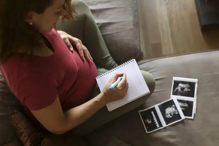 mulher gravida fazendo lista de nomes