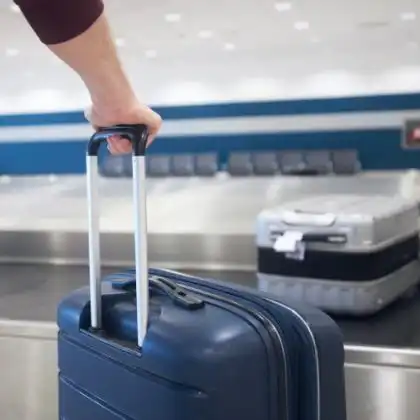 Homem segura a bagagem no aeroporto.