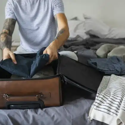 Homem fechando malas antes de viajar para Europa.