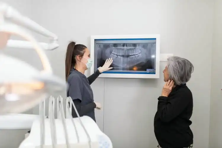 Dentista mostrando raio-x para paciente