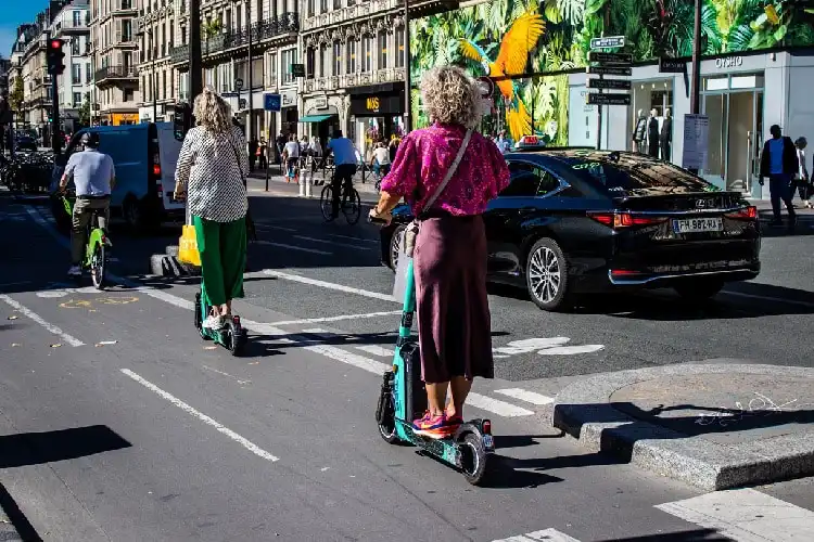 Mulheres andando de patinete em Paris.