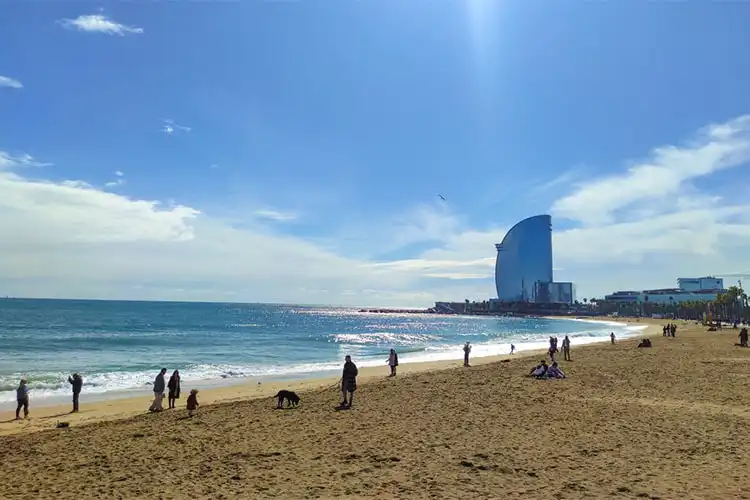 Praia de Barceloneta em dia de muito sol.