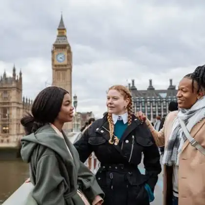 Três mulheres próximas ao Big Ben conversando sobre a importância do inglês para morar na Europa