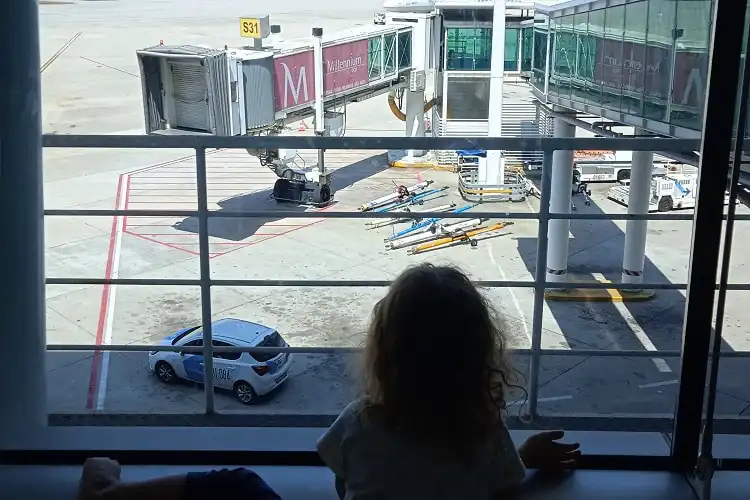 Criança olhando a pista do aeroporto.