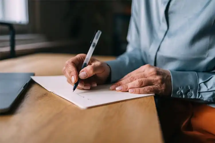 Close-up de mãos e caneta, assinando uma folha