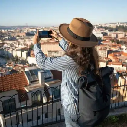 Mulher utilizando um chip Vodafone no celular para fotografar Lisboa, Portugal