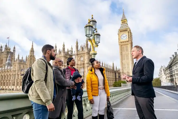 Grupo de turistas com guia em frente ao Big Ben.