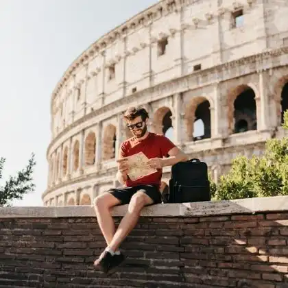 Homem sentado na frente do Coliseu, Roma