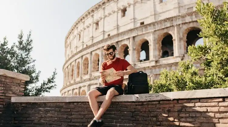 Homem sentado na frente do Coliseu, Roma