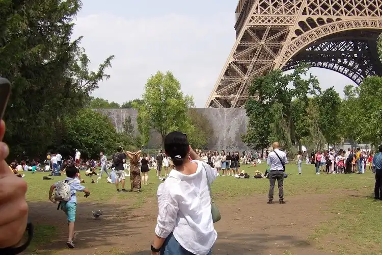 Mulher tirando fotos em Paris, com celular.