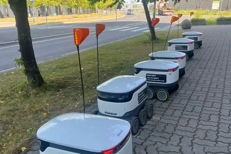 Robôs de entrega de encomendas enfileirados na calçada na Estônia.