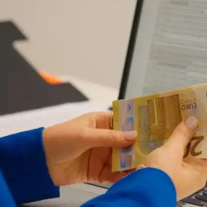 Pessoa contando cédulas de euro, após receber salário mínimo na França.