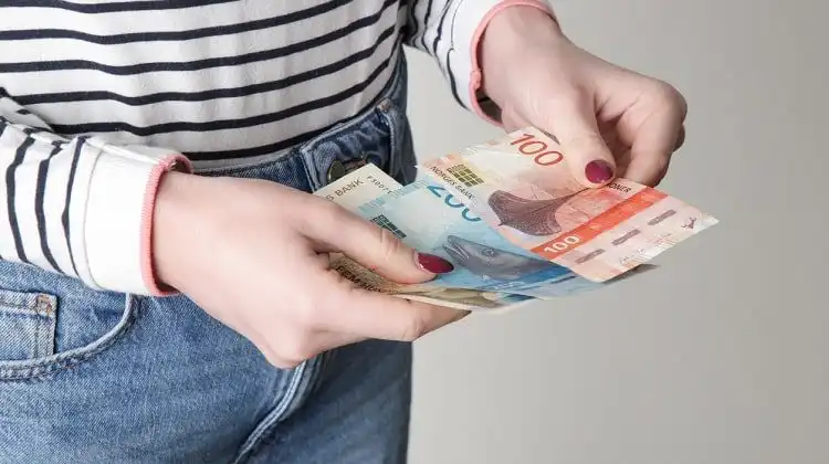 Mulher contando o salário mínimo na Noruega
