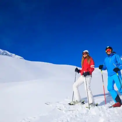 Homem e mulher com equipamento de ski nos alpes.