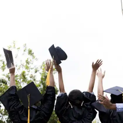 Estudantes recém-formados jogando seus diplomas para o ar