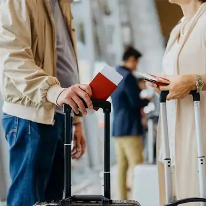 Casal de viajantes com visto para Inglaterra esperando voo no aeroporto.