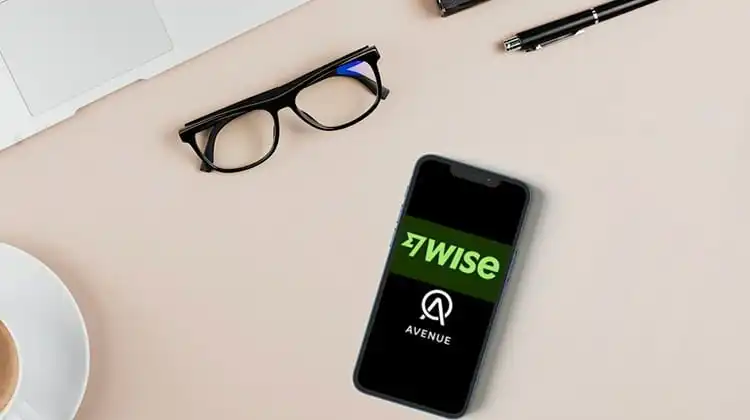 Celular com apps da Wise e Avenue sobre a mesa