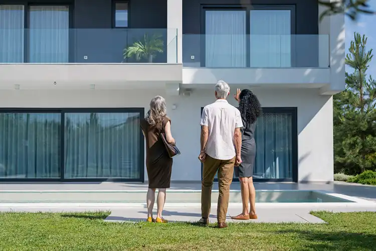 Corretora e clientes em frente a uma casa de luxo para venda em Lisboa