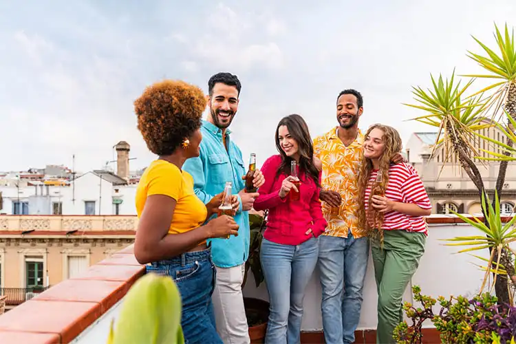 grupo de amigos internacionais conversando no terraço de um prédio