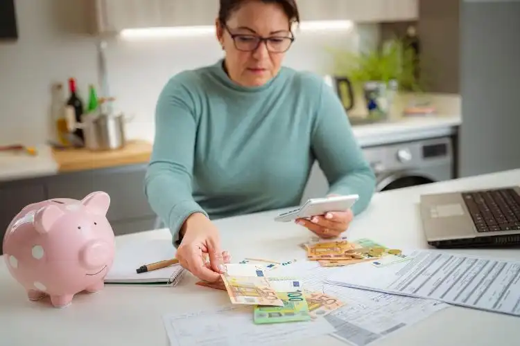 Mulher calculando se vale a pena comprar euro agora.