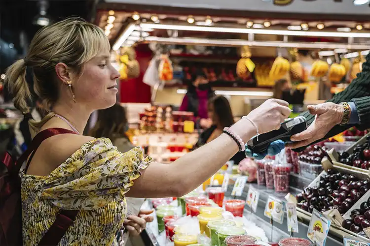 Mulher pagando compra em mercado