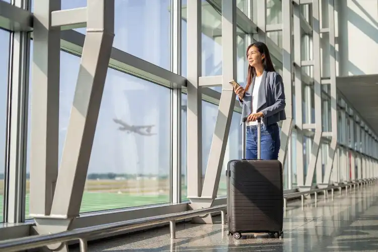 Mulher entrando em contato pelo celular com a GTA no aeroporto.