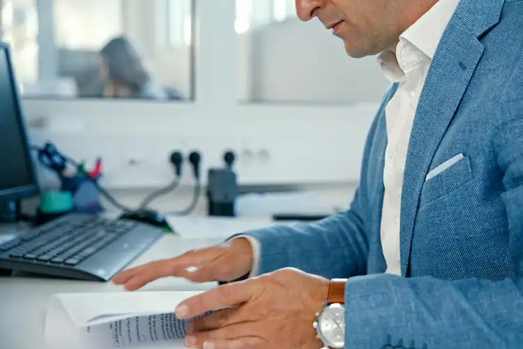 Homem revisa documentos no escritório.