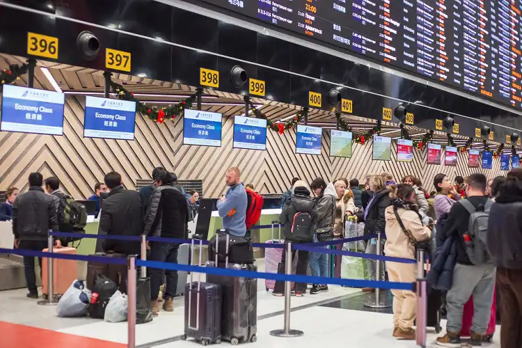 Pessoas em aeroporto lotado, devido a problemas com voo.
