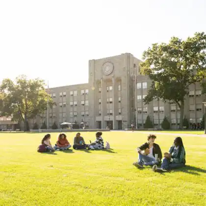 Jovens em frente ao prédio de faculdade de pós-graduação na França