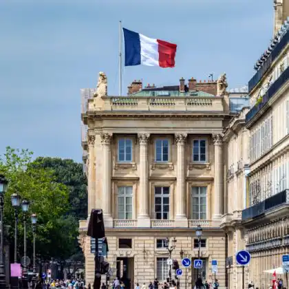 Vista de prédio histórico em Paris, França, com bandeira tricolor francesa no topo
