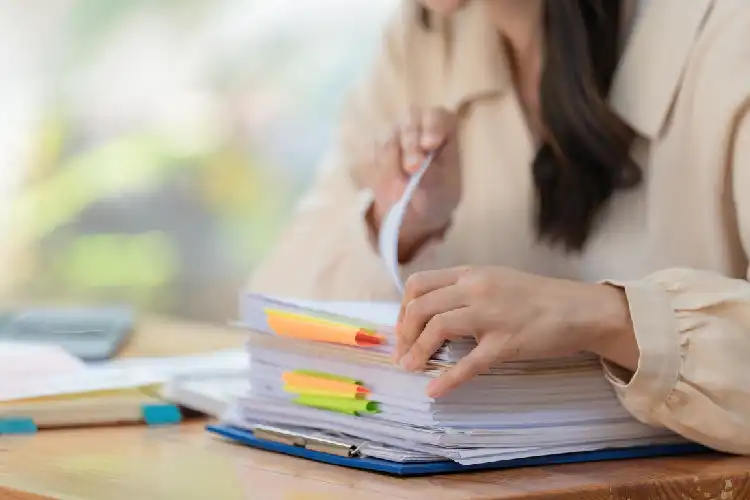 Mulher organizando documentos visto de trabalho na Itália