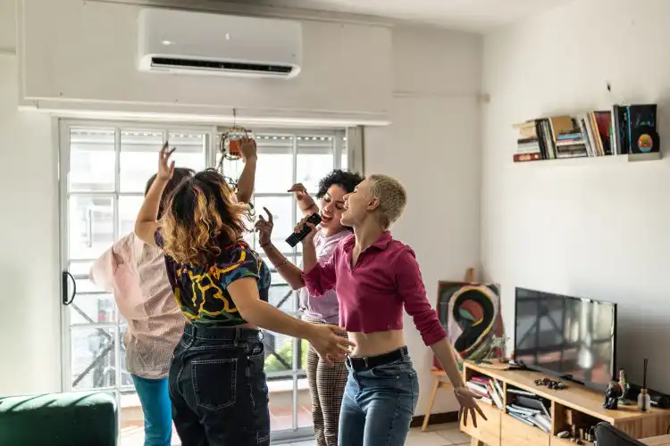 Grupo de amigas cantando no karaokê em quarto em Oxford.