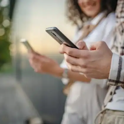Homem e mulher segurando smartphone.