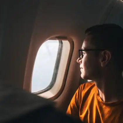 Homem em avião pensa na reinvenção em um novo país.